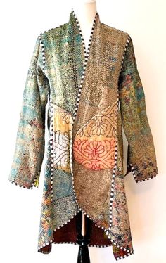 Specialty Collection: Mid Length Designer Jacket Is New and Fully Reversible. Kantha Stitching In emerald or the reverse side, honey. This beautiful NEW handmade vintage cotton kantha jacket is produced by artisans from the nomadic desert tribe known as "Banjara ", Northern India. This jacket is fully reversible; offering two varied prints. Great value. Design detailing is visible throughout the garment. Black and white piping finishes all seams, highlighting the colors and prints well. The coll Bohemian Hand-stitched Outerwear For Fall, Bohemian Hand-stitched Outerwear For Winter, Bohemian Hand-stitched Winter Outerwear, Hand-stitched Bohemian Outerwear For Winter, Hand-stitched Long Sleeve Outerwear For Fall, Poncho Villa, Nomadic Desert, Value Design, Quilted Clothing