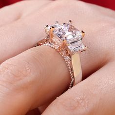 Luxurious and breathtaking, this engagement ring honors the light of your life. Crafted in two tone sterling silver, the ring features an emerald-cut center stone accented with two taper baguette-cut stones on a high polished shank. The shank is buffed to show a bright shine and elegant look. The delicate rose gold tone filigree details on the side of the ring adds elegance and vintage aesthetics to it. Surprised her with this masterpiece!Carat Weight: 3.85 ctStone Size: 7*9 mmStone Type: Jeulia Silver Wedding Ring With Asscher Cut Accent Stones, Square Cut Emerald Ring With Accent Stones For Wedding, Emerald Cut Baguette Diamond Promise Jewelry, Silver Radiant Cut Wedding Ring With Accent Stones, Emerald Cut Rose Gold Wedding Ring With Diamond Accents, Emerald Asscher Cut Ring With Baguette Diamonds For Wedding, Vintage Aesthetics, Baguette Cut, Three Stone