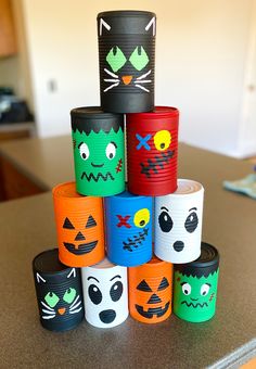 there are many different colored paper cups on the counter top with faces painted on them