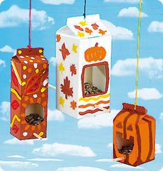 three boxes are hanging from strings in the sky with autumn leaves and pumpkins on them