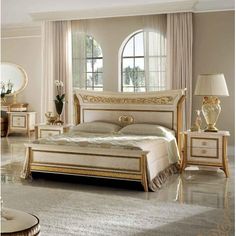 a large white bed sitting in a bedroom on top of a hard wood floor