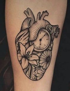 a heart tattoo with flowers and a clock on the inside of it's arm