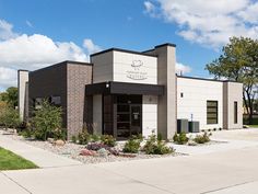 an empty building with landscaping and trees in front