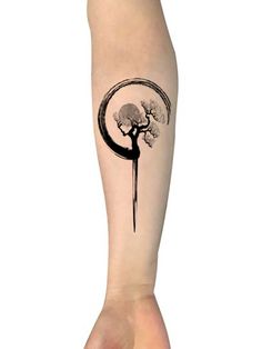 a person's leg with a tree and moon tattoo on the left side of their arm