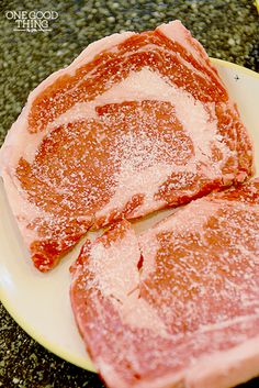 two pieces of meat sitting on top of a white plate