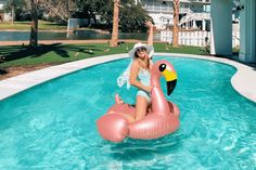 a woman is sitting on an inflatable flamingo pool float at the resort