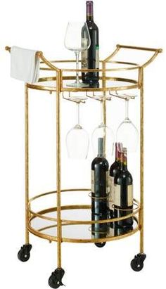 a gold bar cart with two wine glasses and bottles on it, sitting against a white background