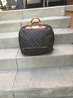 Presenting a vintage Louis Vuitton monogram Evasion travel bag. Great opportunity to own a genuine piece of Louis Vuitton luggage if you are willing to work with this piece. The handles and front leather piece need to be replaced.  With a zipped shoe compartment, it is smaller than Keepall and bigger than Speedy.  It is made of monogram canvas, natural cowhide leather and golden brass hardware. It has a double zipper opening. Comfortable rolled leather handles fall about 4". Inside is lined with canvas lining and has one pocket. It comes with a handle strap. It is marked LOUIS VUITTON PARIS MADE IN FRANCE and guaranteed authentic. Purchased at Neiman Marcus in Beverly Hills, California..   Canvas and inside liner looks great. Leather has turned slightly patina. The handle and leather stain Louis Vuitton Paris, Louis Vuitton Luggage, Louis Vuitton Vintage, Vintage Monogram, Suitcase Traveling, Vintage Louis Vuitton, Leather Pieces, Leather Handles, Suitcases