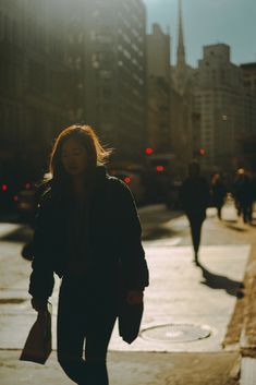 a woman is walking down the street with her hand in her pocket while carrying shopping bags