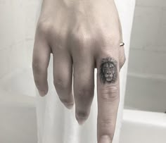 a hand with a small lion tattoo on it