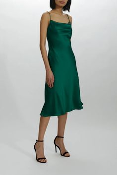 a woman in a green dress posing for the camera