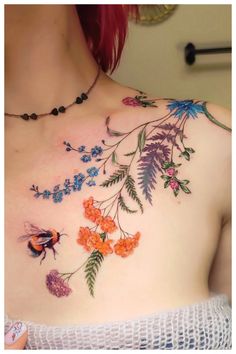 a woman's chest with flowers and bees on it