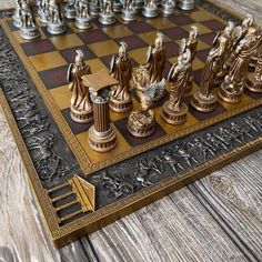 a gold and black chess set on top of a wooden table