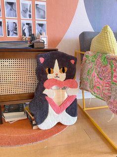 a stuffed animal sitting on top of a wooden floor next to a chair and table