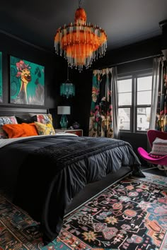 a bedroom decorated in black and orange with a chandelier hanging from the ceiling