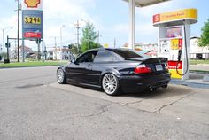 a black car parked in front of a gas station