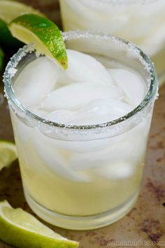 two glasses filled with ice and limes