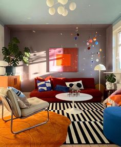 a living room filled with lots of furniture and colorful pillows on top of the couches