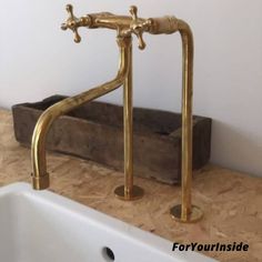 a bathroom sink sitting under a faucet next to a wooden holder with two handles