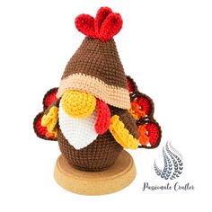 a crocheted turkey hat on top of a wooden stand with an acorn