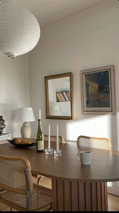 a dining room table and chairs with wine bottles on it