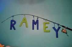 the name ramey spelled out with fishing rods hanging from it's hooks on a wall