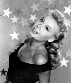 a black and white photo of a woman with stars on the wall in the background