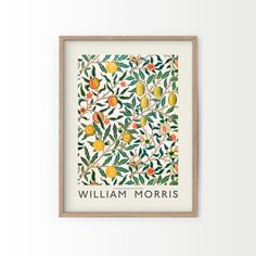 a framed print with an orange tree and fruit on it, in front of a white wall