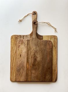 a wooden cutting board on a white background with twine cord hanging from the handle