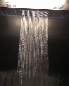 a shower head in the middle of a dark room with lights on top of it