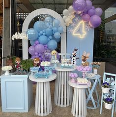 the table is set up with balloons, cake and cupcakes for a frozen world birthday party