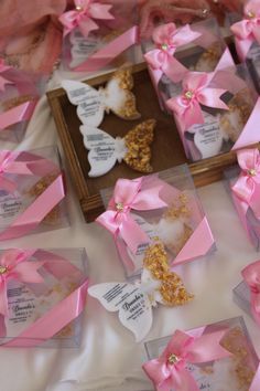 pink and white bows are on display in small clear boxes with tags attached to them