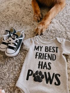 a dog laying on the floor next to a baby's shirt and shoes that says, my best friend has paws