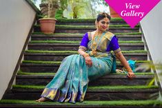 a woman sitting on some steps wearing a sari