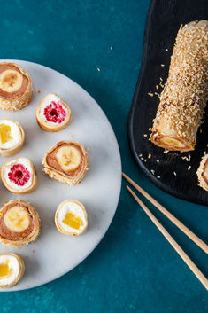 Image shows a blue background with a white plate on. The white plate has what looks like sushi, but is actually fruit wrapped in a pancake. To the right of the white plate there is a black plate, with the sushi pancake roll on, to demonstrate how the roll is created. Sushi Pancakes, Pancake Sushi, Unique Pancake Recipes, Pancakes With Fruit, Maple Pancakes, Easy Dessert Idea