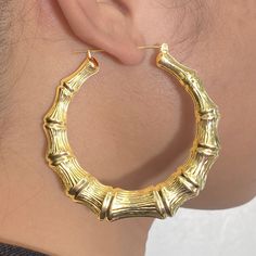 There is nothing more stylish than a pair of 10-karat Yellow Gold Bamboo Hoop Earrings. They're a versatile look that can be paired with any kind of outfit and are suitable for any occasion. The click-snap earring closures support a full hoop shape that is crafted in resilient, eye-catching 10k Yellow Gold. Its gold composition is tougher than most gold types, allowing it to withstand years of daily wear. These hoops measure 2.90 inches from side to side. Bamboo Hoop Earrings are a wonderful gif Trendy Yellow Gold Hoop Earrings, Bamboo Jewelry, Clean Gold Jewelry, Bamboo Hoop Earrings, Bamboo Earrings, Nothing More, 10k Gold, Gold Chains, Pink And Gold