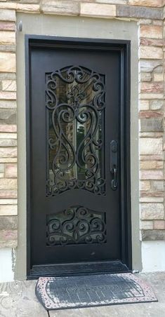 an ornate iron door on the side of a brick building