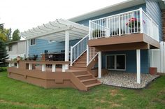 a patio with steps leading up to a deck and attached pergolan roof over it