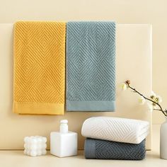 towels and soaps are lined up on the counter in front of a vase with flowers