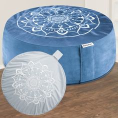 a blue and white ottoman sitting on top of a wooden floor next to a round pillow