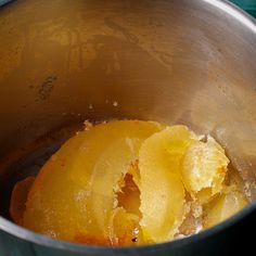 peeled oranges sit in a metal pot on the stove top, ready to be cooked