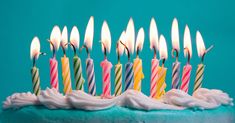 a birthday cake with many lit candles on it's blue frosted icing