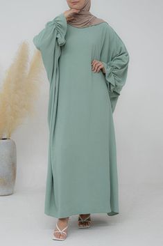 Our Radwa batwing abaya features a loose cut for a comfortable fit, with ruched sleeves and a flattering silhouette. Stylish but practical, it's perfect for your daily wardrobe as well as prayer, omrah or hajj. The trendy color style makes it easy to pair with any outfit. This classic design provides an elegant look while the relaxed fit allows freedom of movement. With a subtle hint of trendy mint green, this abaya is a versatile and stylish staple for any fashion wardrobe. Perfect for any occa Green Flowy Long Sleeve Kaftan, Flowy Green Long Sleeve Kaftan, Green Oversized Casual Kaftan, Casual Oversized Green Kaftan, Green Oversized Long Sleeve Kaftan, Oversized Long Sleeve Green Kaftan, Batwing Abaya, Ruched Sleeve, Loose Dress