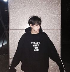 a young man wearing a black hoodie with the words what's who do you? written on it