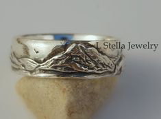 Mountain Band- Teton Mountain / Horse in Wedding Band / Mountain range with beautiful detailed Grand Tetons as the main feature in this landscape rustic wedding band. This peak soars 13,770 ft. above sea level and is spectacular!  A mountain landscape with a sunrise and horse or no animal.  Fantastic ring for the Hiker, outdoor mountain lover.   This listing is for the band only.  I meticulously carve this design in wax to capture the details and then cast it in solid sterling silver.  The photo Engraved Thick Wedding Bands, Rustic Silver Jewelry For Wedding, Rustic Hand Forged Wedding Rings, Adjustable Thick Band Wedding Bands, Adjustable Thick Band Wedding Ring, Adjustable Thick Band For Wedding, Rustic Silver Wedding Rings, Handmade Silver Bands For Wedding, Adjustable Etched Wedding Bands