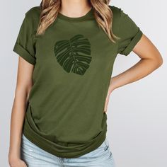 a woman wearing a green t - shirt with a palm leaf on it