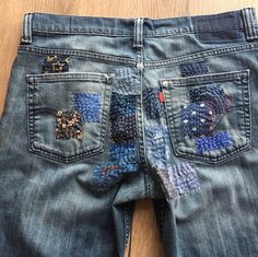 a pair of jeans with patches on them