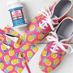 a pair of pink shoes with pineapples on them next to glue and scissors