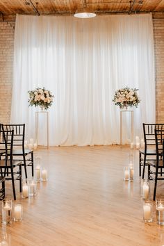 the ceremony room is decorated with candles and floral centerpieces