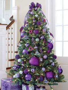 a purple christmas tree with presents under it